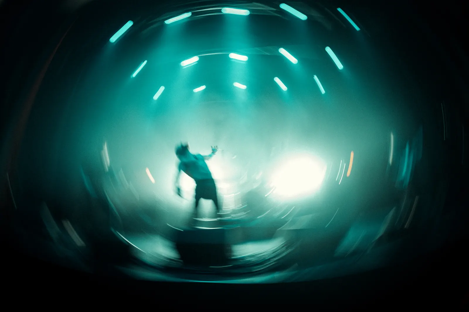Live music photo with radial stage light and a musician silhouette.